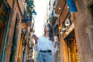 Pensive woman drinking coffee on street in town