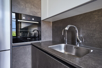 oven next to the sink in the modern kitchen