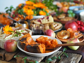 Fototapeta na wymiar Fragment of a set table with orange marigold flowers. Thanksgiving Day. Healthy rustic natural food.