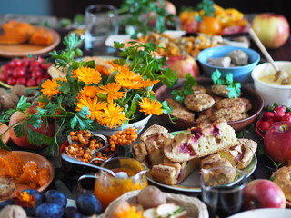 Fragment of a set table with orange marigold flowers. Thanksgiving Day. Healthy rustic natural food.