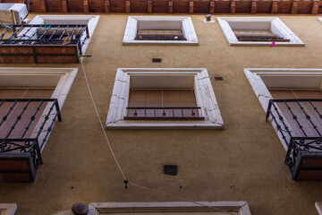 Looking up at vintage apartment windows of old building in Spain