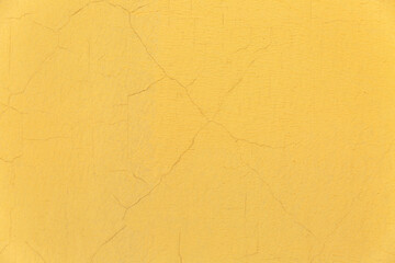 Yellow concrete wall with cracks. Background. Space for text. Exterior of the building.
