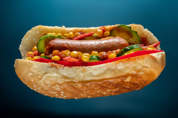 Hot dog with corn and vegetables. Fast food with sausage and vegetables. The dock is in a suspended position. Isolate.