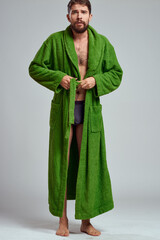 emotional man in a green robe on a light background in full growth fun emotions model