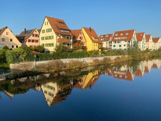 Obraz premium Bunte Häuserreihe spiegelt sich glatt im Wasser