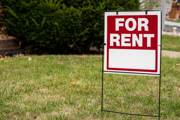 For rent sign in the yard in front of a house