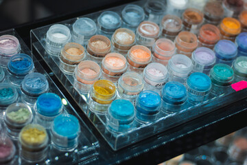 Mineral eyeshadow. Many jars with multi-colored eyeshadows. Exhibition of cosmetics