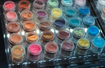 Mineral eyeshadow. Many jars with multi-colored eyeshadows. Exhibition of cosmetics