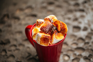 Hot beverage with toasted marshmallows in red mug