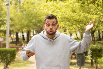 attractive man surprised with mobile phone outdoors