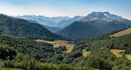 Fototapeta na wymiar Panorama of Abkhazia valley at Caucasian mountain ridge background with Acetuka and Pshegishkha peaks at sunny summer day.