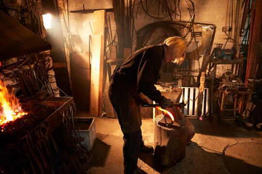 Female blacksmith working in workshop