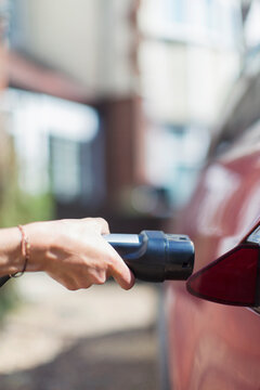 Close up woman recharging electric car