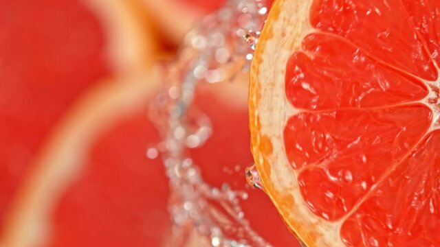 Super Slow Motion Shot of Splashing Water from Rotating Grapefruit Slice at 1000fps.