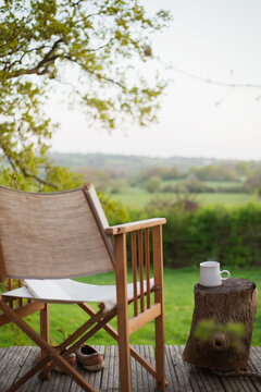 Book and chair on balcony overlooking rural field