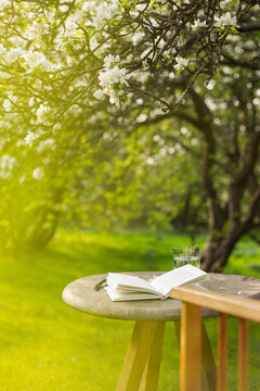 Open journal on table in sunny idyllic garden