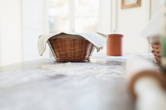 Bread dough proofing in basket on kitchen counter
