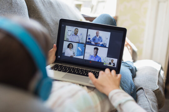 Teenage girl video chatting with doctors on laptop screen
