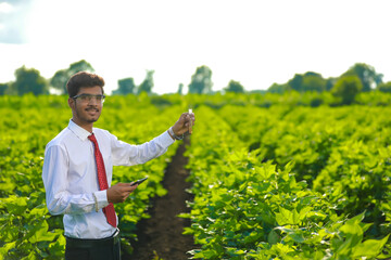 young indian handsome agronomist with test tube and tablet