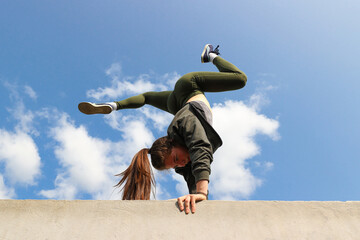 A girl stands on her hands on a sports field