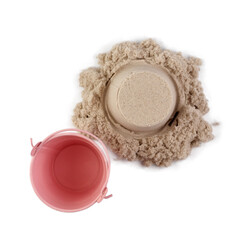 Bucket and sand isolated on white background. Decorative small pink bucket and kinetic sand, with...