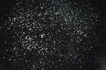 Fototapeta na wymiar Christmas Silver glitter on black background. Holiday abstract texture