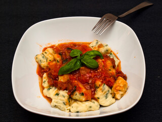 Herb gnocchi with tomato sauce and basil