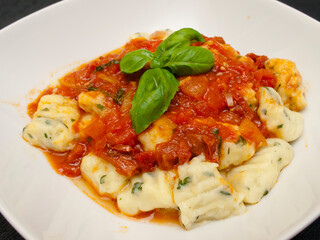 Herb gnocchi with tomato sauce and basil