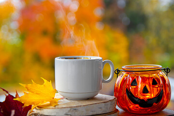 against the background of a blurred autumn bright forest stands a still life of Halloween decor...