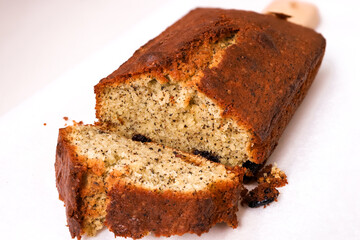 Black Tea Butter Pound Cake with Raisins and tea leaves. Sliced on a wooden cutting board with white background. Close-up view of the fragrant patisserie and macro view of the texture of pound cake.