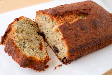 Black Tea Butter Pound Cake with Raisins and tea leaves. Sliced on a wooden cutting board with white background. Close-up view of the fragrant patisserie and macro view of the texture of pound cake.