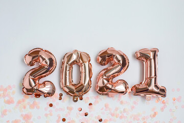 Foil balloons in the form of numbers 2021 and confetti