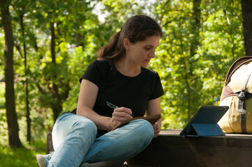 A girl studies online in a Park. Distance learning concept. Education concept