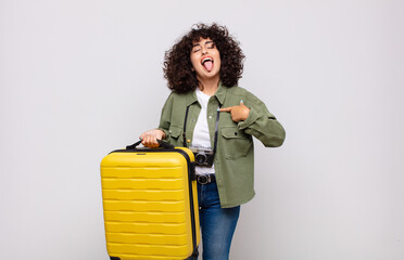 young arab woman with cheerful, carefree, rebellious attitude, joking and sticking tongue out,...