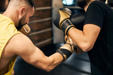 Male boxer attacking opponent with a right hook