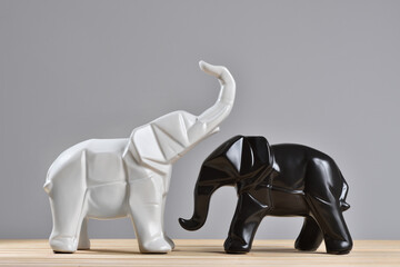 Figurines of white and black elephants in geometry style for decoration