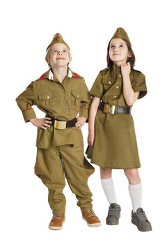 Thoughtful boy and girl wearing USSR military uniform.are holding hands isolated at white background. Concept of children friendship.