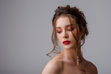 Beauty portrait of young beautiful brunette woman with colorful makeup: pink, red eyeshadow, bold lipstick, elegant hairstyle. Copy, empty space for text
