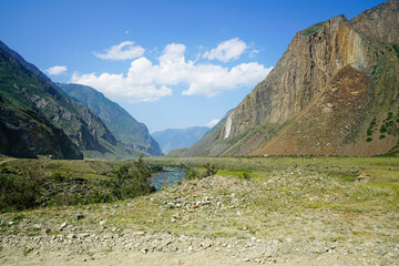 Landscape with a river flowing through a valley between the mountains