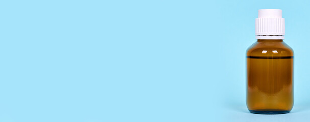 Medical bottle, pharmacy drug in glass container, isolated on blue background, copy space template, banner.