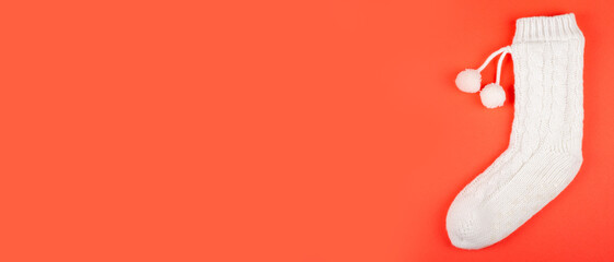 Obraz premium White socks with pom poms on red background composition. Flat lay and top view photo with copy space.
