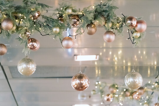 Christmas decorations hanging from ceiling in modern mall, shopping center  or exhibition place. Baubles hanging on trees branch Stock Photo