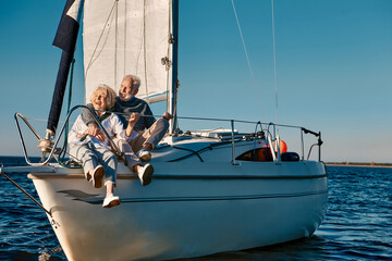 Sea trip. Happy beautiful senior family couple hugging and having fun while relaxing on a sail boat...