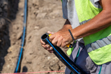 Worker hands cutting polypropylene pipe