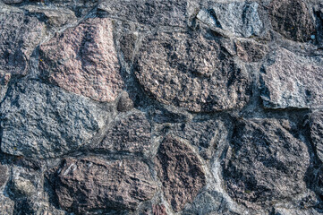 Background of the wall of large granite textured stones, horizontal view
