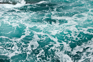 Fototapeta premium Waves and white foam at the sea. Watching the blue water building pattern.