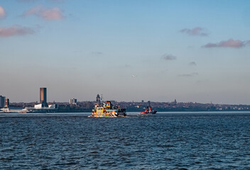 Liverpool, UK. Beautiful colorful long exposure shot of river Mersey from Albert Dock with smooth reflections of night lights from the other side of a shore and a boat. 