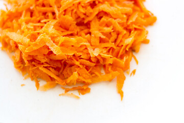 grated carrots on white background