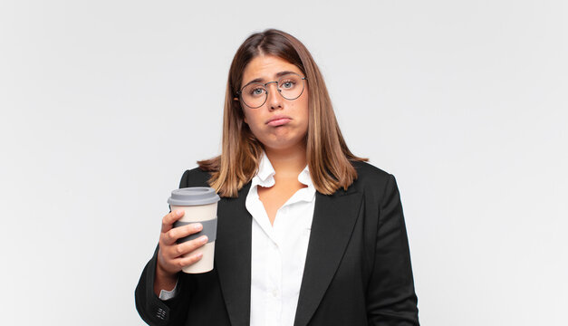young businesswoman with a coffee feeling sad and whiney with an unhappy look, crying with a negative and frustrated attitude