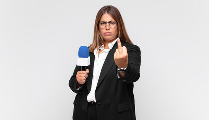 young woman reporter feeling angry, annoyed, rebellious and aggressive, flipping the middle finger,...
